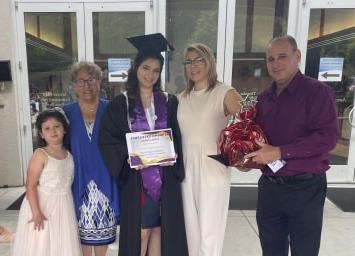 Image of Claudia in her graduation gown along with her family showing her diploma from Georgia Connections Academy. 